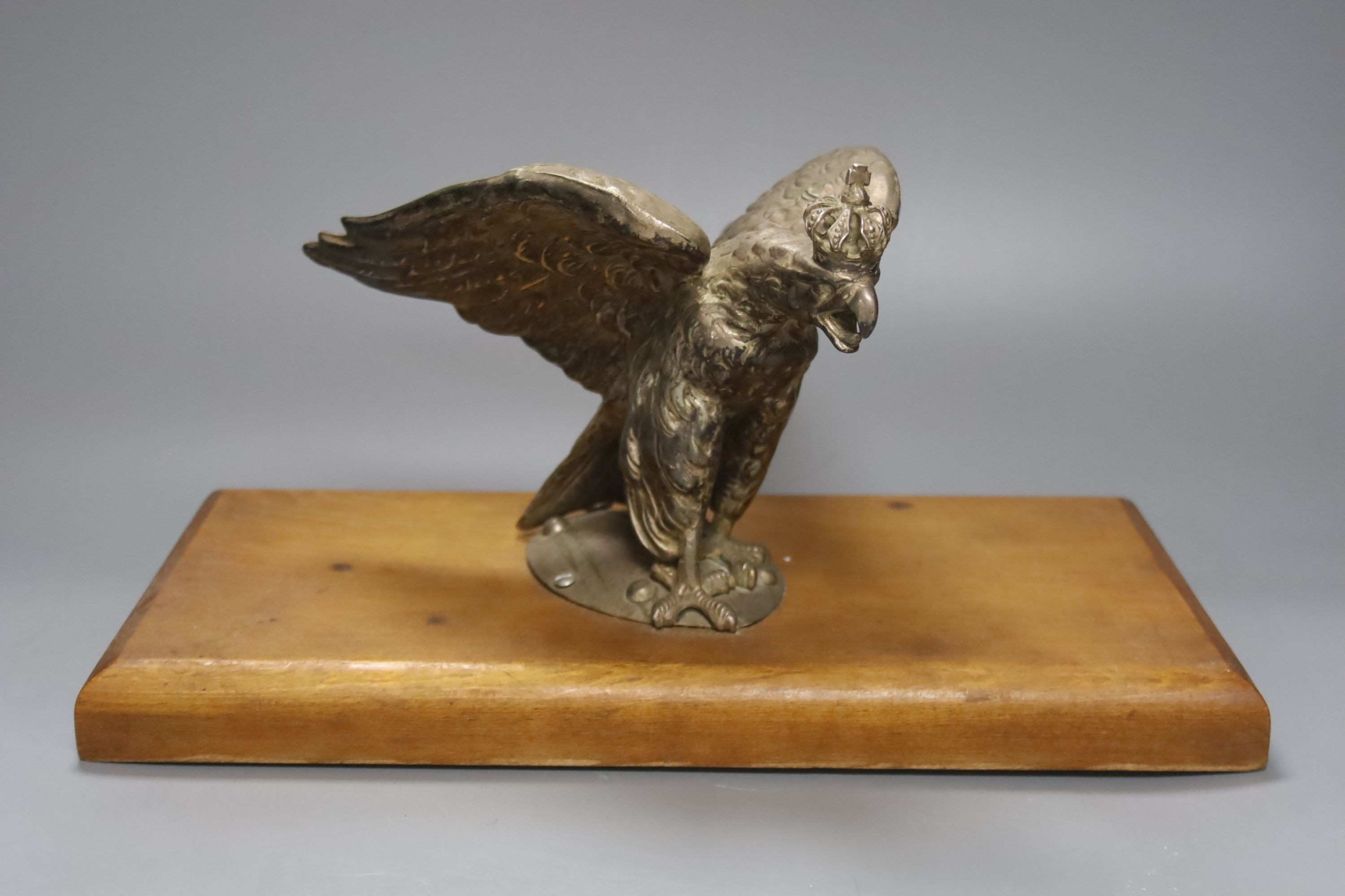 A plated Prussian eagle finial for a Prussian Guard’s helmet, later wood plinth, W36cm